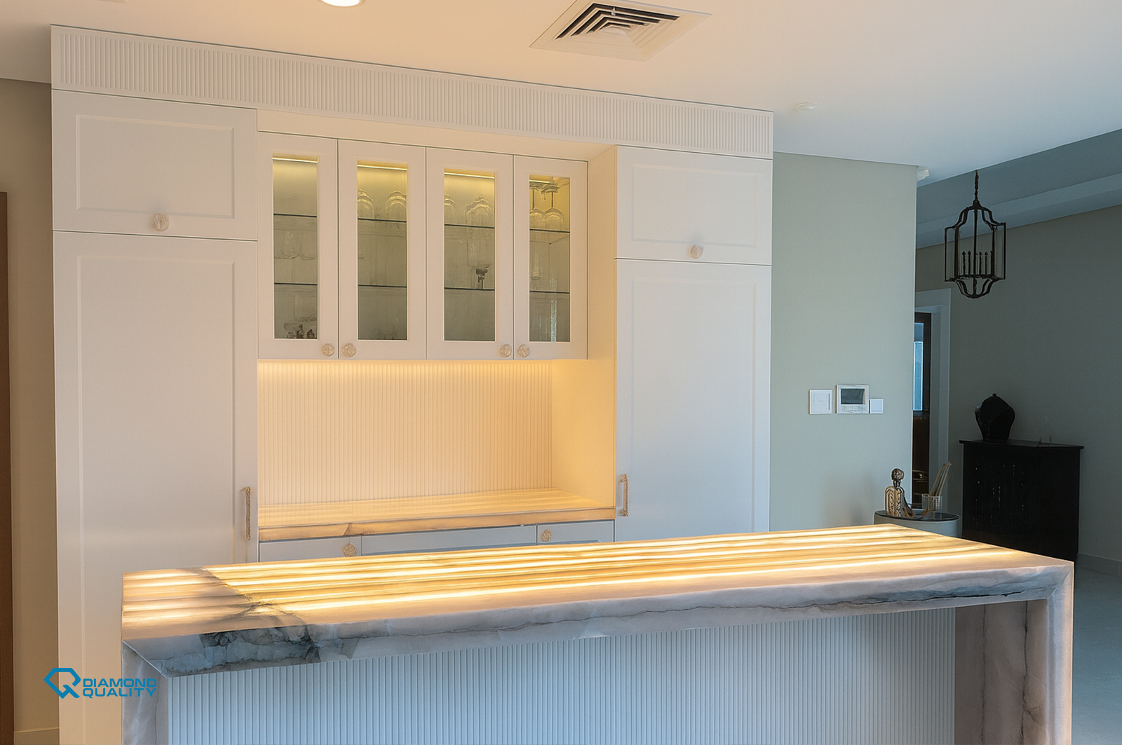 Elegant white kitchen cabinetry with soft linear lighting – High End Apartment Renovation Sharjah