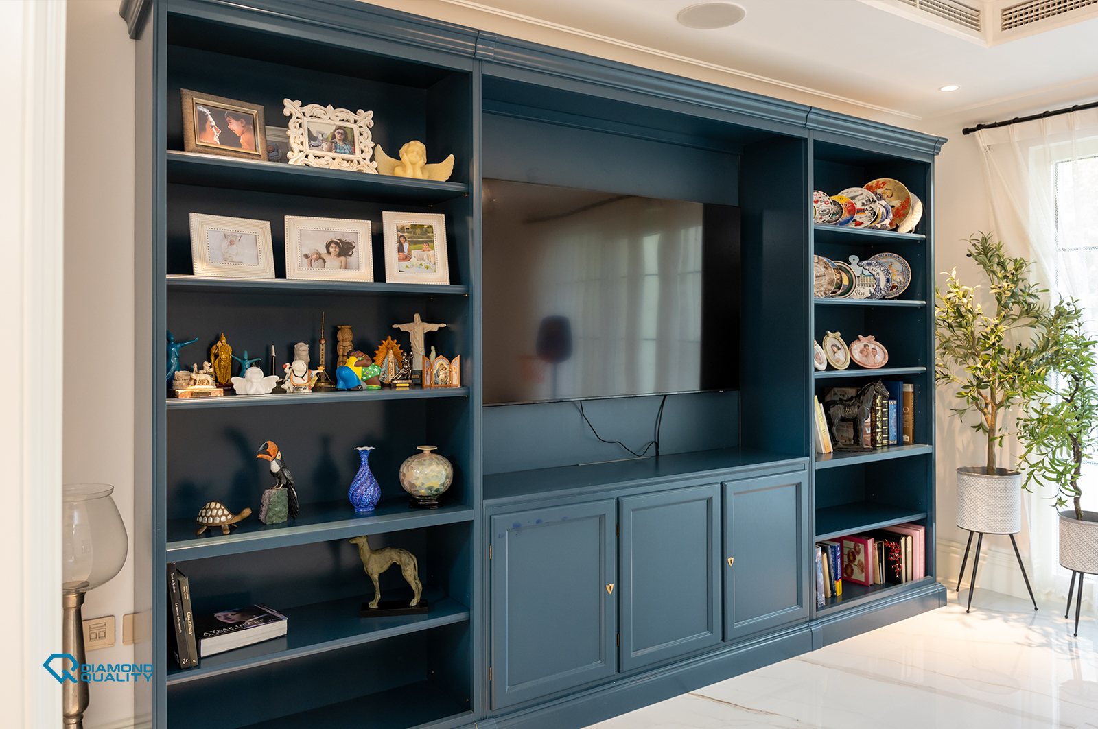 Built-in navy blue TV unit with display shelves and luxury décor in Dubai villa.