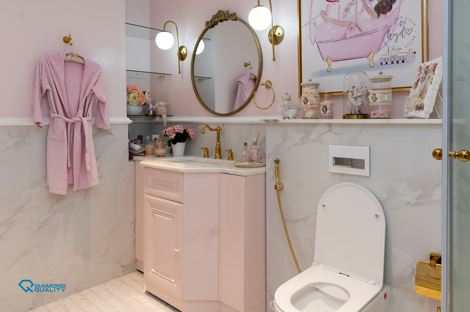 Soft pink bathroom with gold fixtures, marble tiles, and vanity design by Diamond Quality.