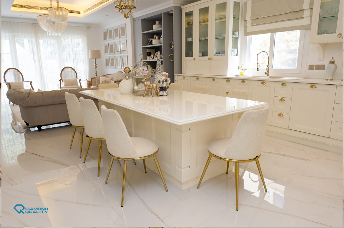 Open kitchen and living area with white marble flooring and gold lighting details in classic modern villa renovation Dubai.